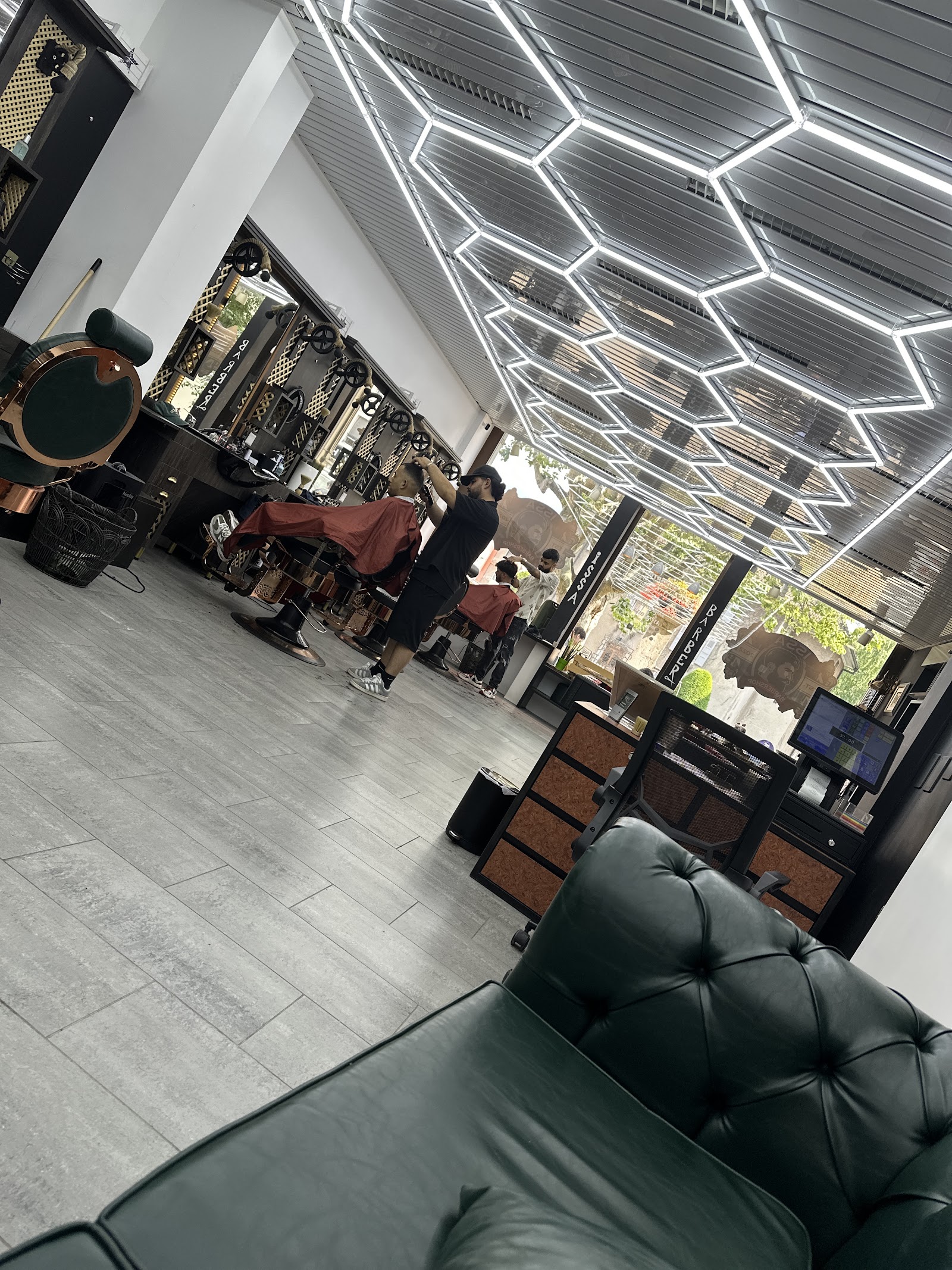 Interieur moderne du salon avec plafond hexagonal lumineux et canape Chesterfield