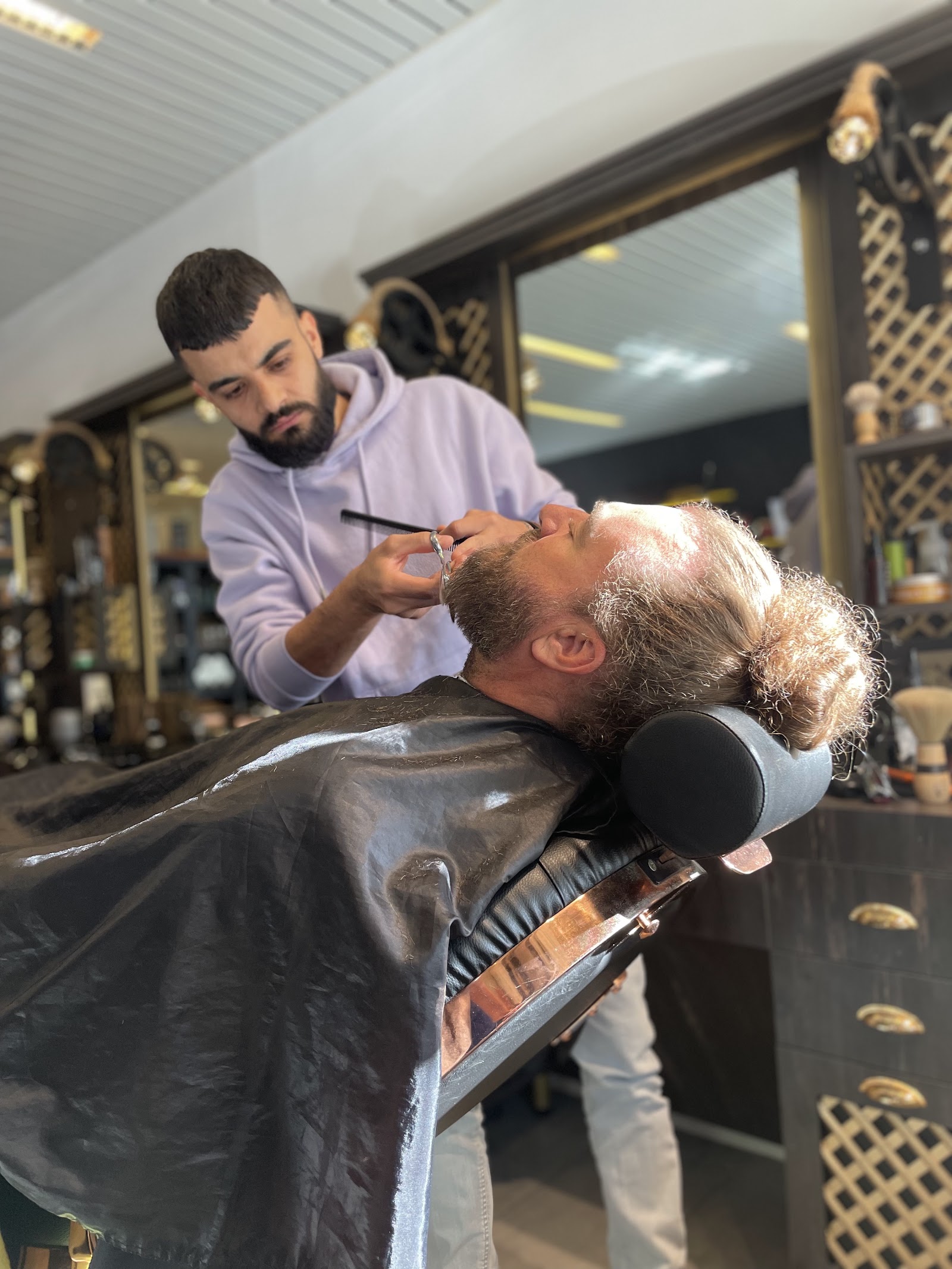 Issa taillant la barbe d'un client au ciseau - le geste precis du barbier