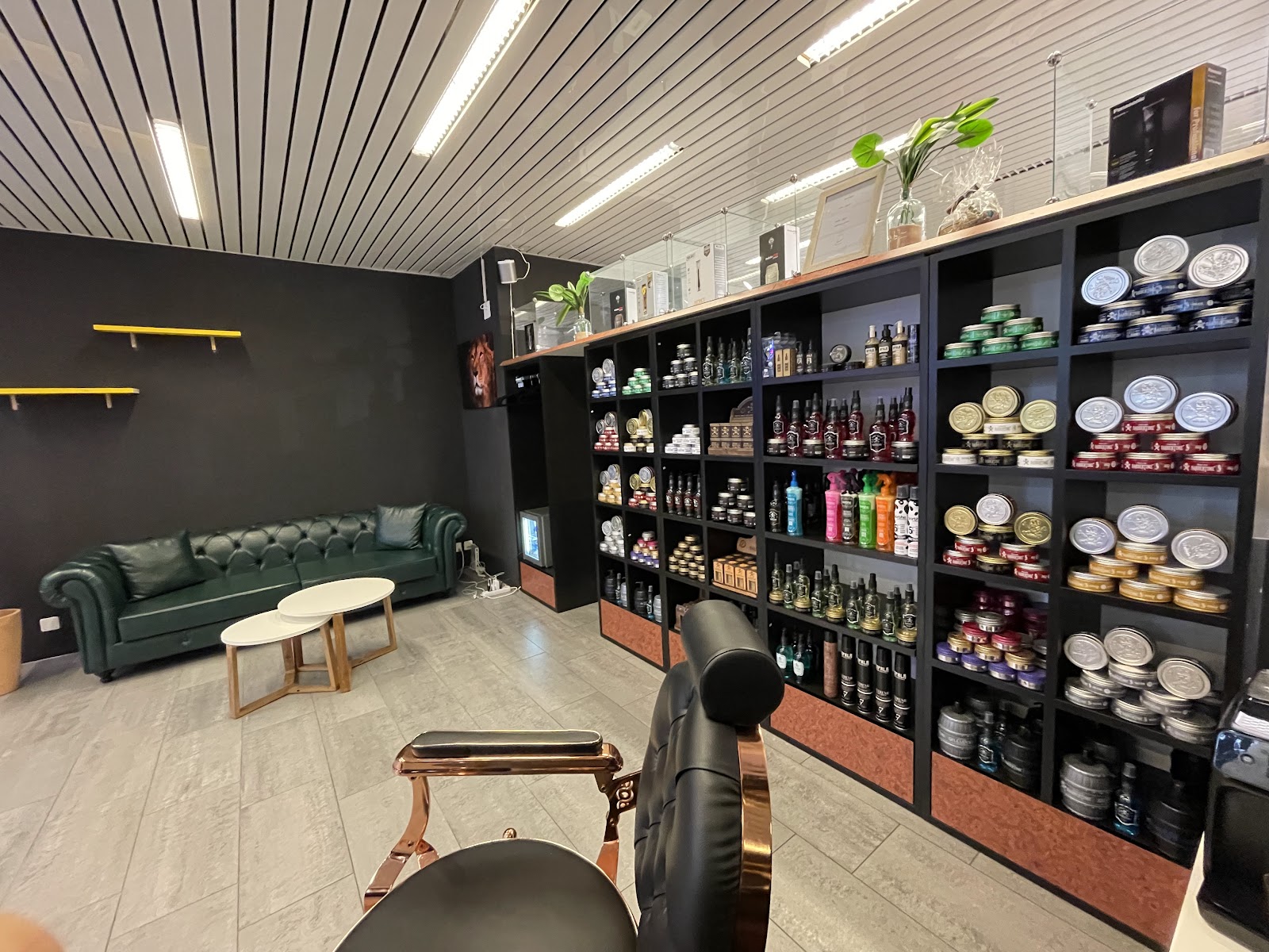 Espace d'attente avec canape Chesterfield et etageres de produits de soins